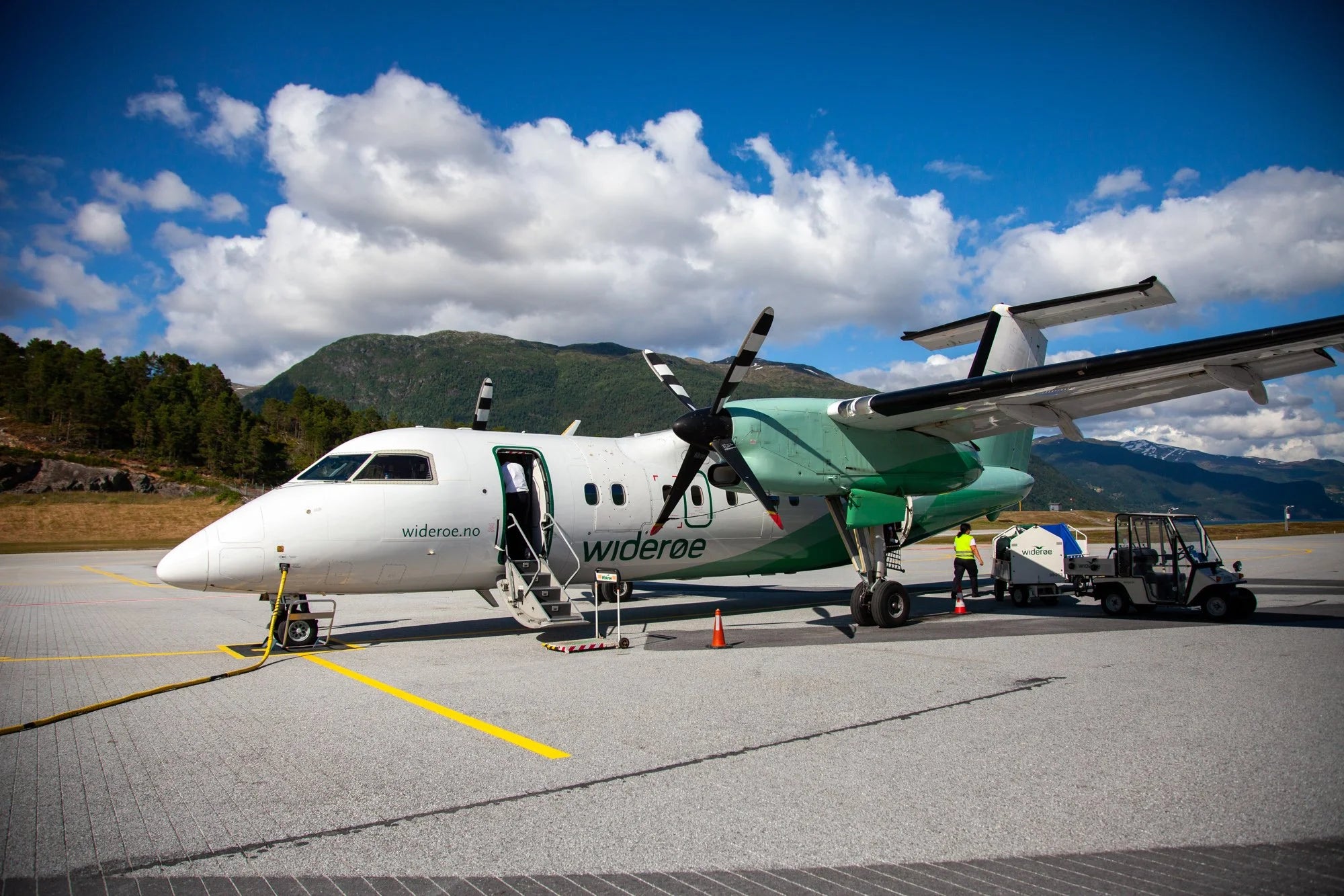Small airplane on a runway with mountains in the background