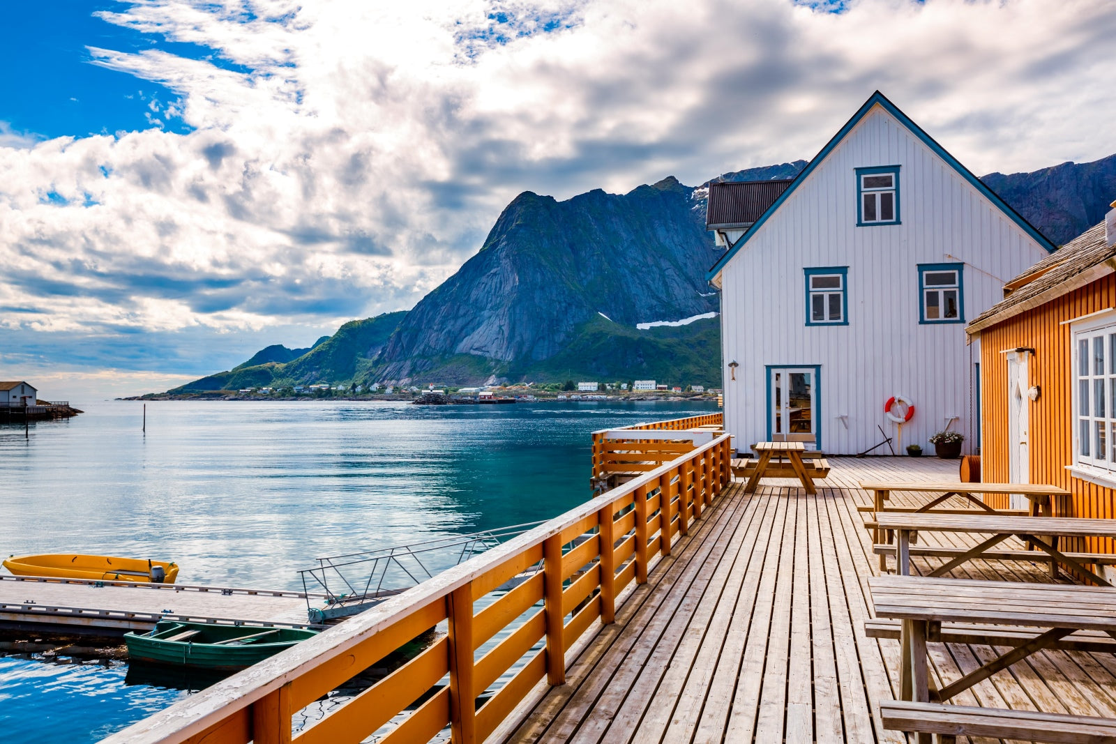 Scenic view of a coastal town with houses, a dock, and mountains.