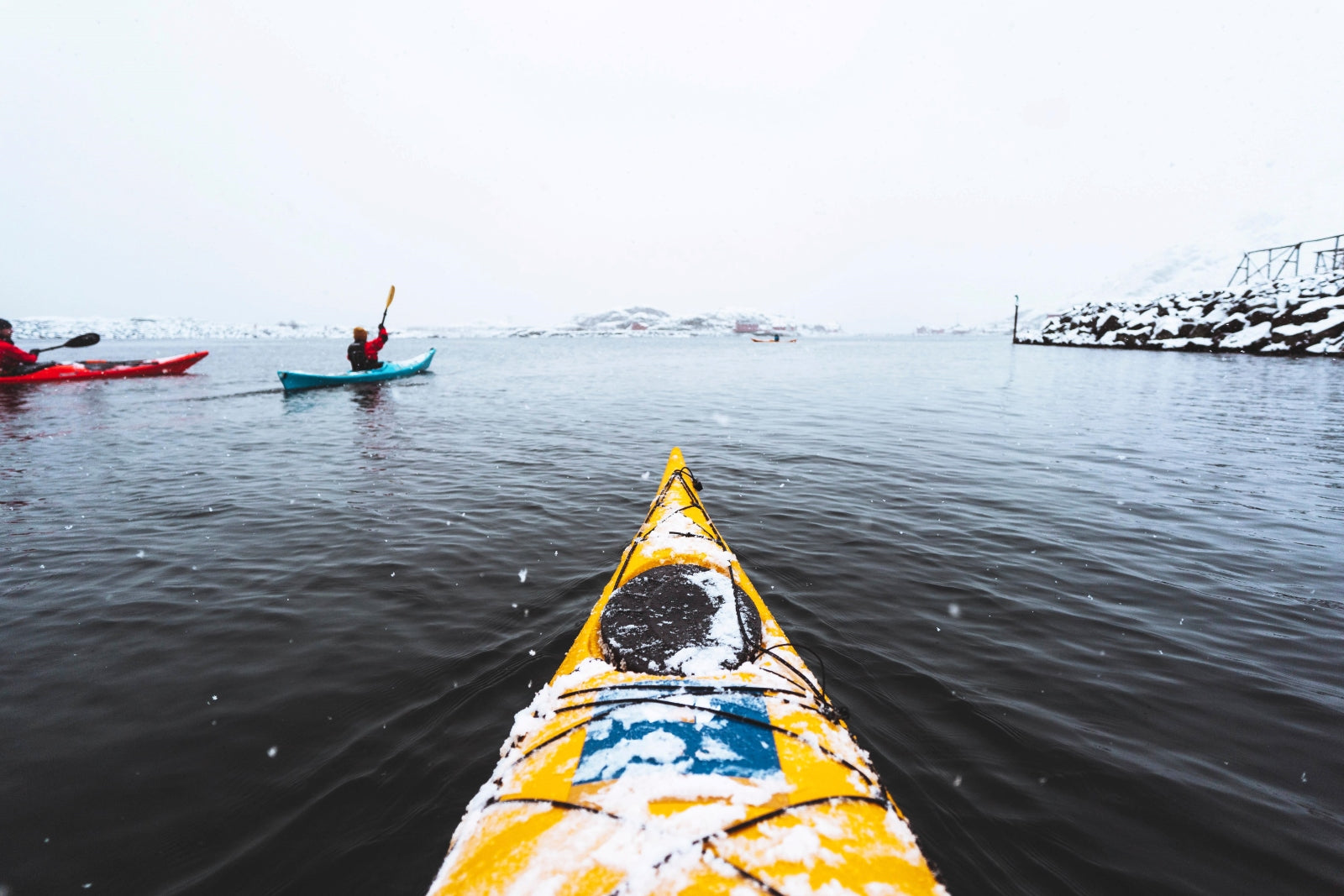 Yellow kayak on a body of water with other kayaks in the background